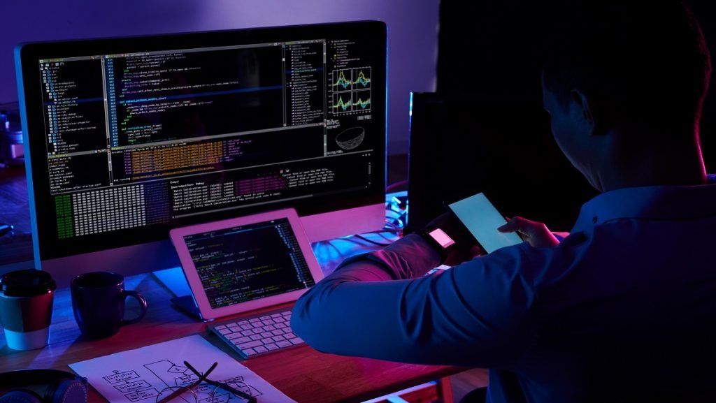 Un programmeur en train de gérer l'algorithme Google avec son Smartphone, sa tablette et son MacBook.