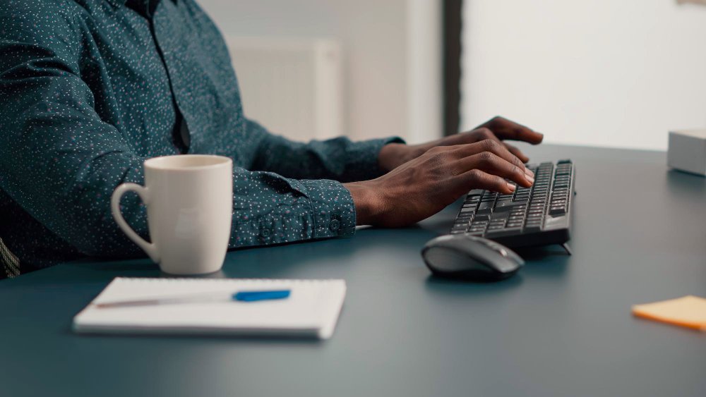 Homme tapant sur clavier ordinateur